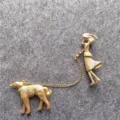 Spilla vintage in metallo dorato con una donna elegante che porta a spasso un cane - Stile Donna di Moda E Levriero (B1) / Oro