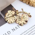 Makroaufnahme einer goldenen Vintage-Blattbrosche mit feiner Aderstruktur - Doppelblatt Design