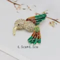 Detailed view of a vintage hummingbird brooch with colorful enamel and rhinestones - Emerald Golden Brown Hummingbird Flight Style (BK05)