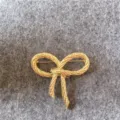 Dettaglio di spilla a fiocco d'oro vintage con design intrecciato per moda femminile - Stile Fiocco Intrecciato Vintage (B4) / Oro