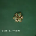 Detailed view of vintage Baroque brooch with green gemstones and white pearls. - Green Gemstone Pearl Style (B2)