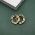 Detailed macro view of a vintage Baroque style gold brooch featuring elegant pearl embellishments - Intertwined Double Circle Pearl Style