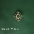 Detailed view of a vintage baroque green gemstone brooch with pearls - Hollow Green Gem Style (B3)