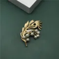Detail view of vintage gold feather brooch with elegant white pearls for banquet - Feather Ginkgo Leaf Style
