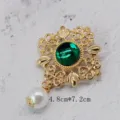 Macro view of vintage gold brooch with large green stone and elegant white pearl drop detail - Baroque Hollow Green Pendant Style (BK01)