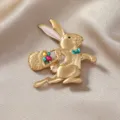 Exquisito broche de conejo vintage en oro mate con cesta de huevos de Pascua de colores - Conejo Corriendo