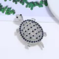 Close-up van een zilverkleurige schildpadspeld met schitterende blauwe kristallen - Zeeschildpadstijl (Stijl 7)