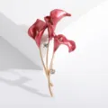 Macro view of elegant red enamel calla lily brooch with gold stems and rhinestones. - Red
