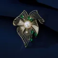 Luxury emerald leaf brooch with white pearl and sparkling crystals on navy background - Gold Hollow Leaf Emerald Zirconia