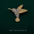 Detailed close-up of a sparkling rhinestone hummingbird brooch on green fabric - White Hummingbird Style (V5)