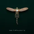 Detailed view of elegant gold dragonfly brooch featuring white pearl and green crystals - Dragonfly Style (V1)