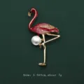 Detailed view of an elegant red flamingo enamel brooch with white pearl accent on dark green - Flamingo Style (V12)