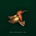Detailed view of an elegant enameled hummingbird brooch with gold and orange accents. - Yellow Hummingbird Style (V15)