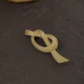 Detailed view of vintage gold knot brooch with intricate Baroque textured metal finish. - Matte Gold Twisted Knot Ribbon Style