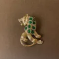 Detailed macro view of a vintage gold-plated leopard brooch set with green emerald-like stones - Emerald Leopard Sitting Style (Style 9)
