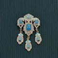 Detailed view of a vintage Baroque style brooch with rhinestones and teal cabochons. - Green Gemstone Pendant Style / Style 1