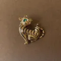 Detailed view of a vintage baroque gold cat brooch with black stripes and green eye - Enamel Tabby Sitting Cat Style (Style 10)