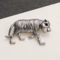 Detailed close-up of a vintage silver tiger brooch with intricate stripes and stone eyes - Antique Silver Tiger Black Stone Eyes