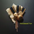 Primer plano de un broche barroco vintage con borlas doradas y cinta de rayas elegante - Estilo Borla Heráldica (6)
