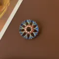 Close-up view of a vintage Baroque enamel floral brooch with delicate white pearls - Hollow Blue Sun Flower Style