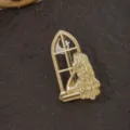 Nahaufnahme einer goldenen Vintage-Brosche im Barockstil mit einer Frau am Fenster - Mädchen am Fenster und Mondsichel-Design