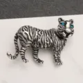 Detailed view of a vintage silver tiger brooch with sparkling blue rhinestone eyes. - Antique Silver Tiger Blue Stone Eyes