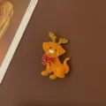Close-up of vintage golden enamel dog brooch with reindeer antlers and red bow tie - Christmas Antler Dog Style