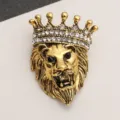 Detailed macro view of a vintage gold lion head brooch with crystal crown embellishment - Vintage Crown Lion Head Gold