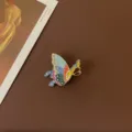 Close-up detail of a vintage baroque butterfly enamel brooch with colorful patterns. - Colorful Vibrant Butterfly Style
