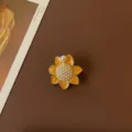 Macro detail of a vintage enamel flower brooch with elegant pearl embellishments - Orange Floral with Pearl Style