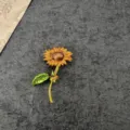 Detailed view of a vintage enamel sunflower brooch with vibrant yellow and green accents - Sunflower Flower Style