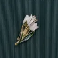 Detail view of a vintage baroque white tulip brooch with green leaves and gold plating - Style 10