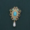 Macro view of a vintage Baroque brooch with turquoise and pearls on green background - Blue Sapphire Pearl Pendant Style / Style 3