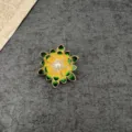 Detailed view of a vintage baroque sunflower brooch with yellow enamel and pearl center - Baroque Sunflower Style