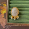 Vintage Baroque cameo brooch with gold frame and pearl pendants on green velvet tray. - Cameo Portrait Triple Pearl Tassel Style (Style 13)