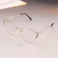 Detalle de cerca de unas elegantes gafas de ojo de gato de metal dorado con detalles de strass. - 0° Anti-Blue Light / Montura Oro Negro