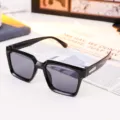 Close-up of stylish black square sunglasses with dark lenses on an open magazine - Glossy Black Square Style (86664) / Glossy Black/Grey Lens