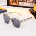 Modern translucent grey square sunglasses with smoke lenses shown on a white table - Transparent Grey Square Style (86664) / Transparent Grey Frame Grey Lens