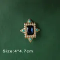 Close-up view of a vintage Baroque style brooch featuring a deep blue gemstone and pearls - Deep Blue Gem Style (B7)