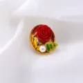 Dettaglio ravvicinato di spilla barocca vintage con rosa rossa uccello e perla - Decorazione Rosa Rossa e Uccello