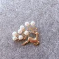 Close-up macro view of a vintage golden reindeer brooch featuring elegant white pearls - Deer Style (B1) / Gold
