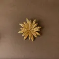 Detailed view of vintage golden sunburst brooch with a textured radial wheat design - Vintage Sunflower Style (Style 5)
