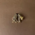 Detailed view of a vintage gold-toned leopard brooch with black enamel spots and green eyes - Spotted Leopard Style (Style 3)