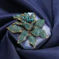 Elegant vintage flower brooch pin featuring teal crystals with an antique gold finish - Teal Blue Vintage Flower