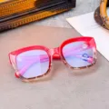 Dettaglio di eleganti occhiali rossi a montatura quadrata con lenti anti-luce blu. - Leopardo Rosso Sfumato