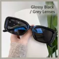 Glänzende schwarze rechteckige Sonnenbrille mit grauen Gläsern für einen stilvollen Look. - Sonnenbrille / Glänzend Schwarz/Graue Linse