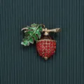 Vintage baroque acorn brooch featuring sparkling red rhinestones and green enamel leaf. - Style 6