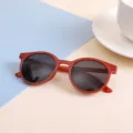 Round frame cute children's sunglasses in stylish terracotta red color with dark lenses - Red