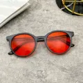 Trendy kids sunglasses featuring a black round frame and vibrant red candy color lenses - Black Frame Red Lens
