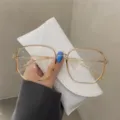 Primer plano de gafas de montura cuadrada grande en color té transparente para mujer - Naranja Transparente
